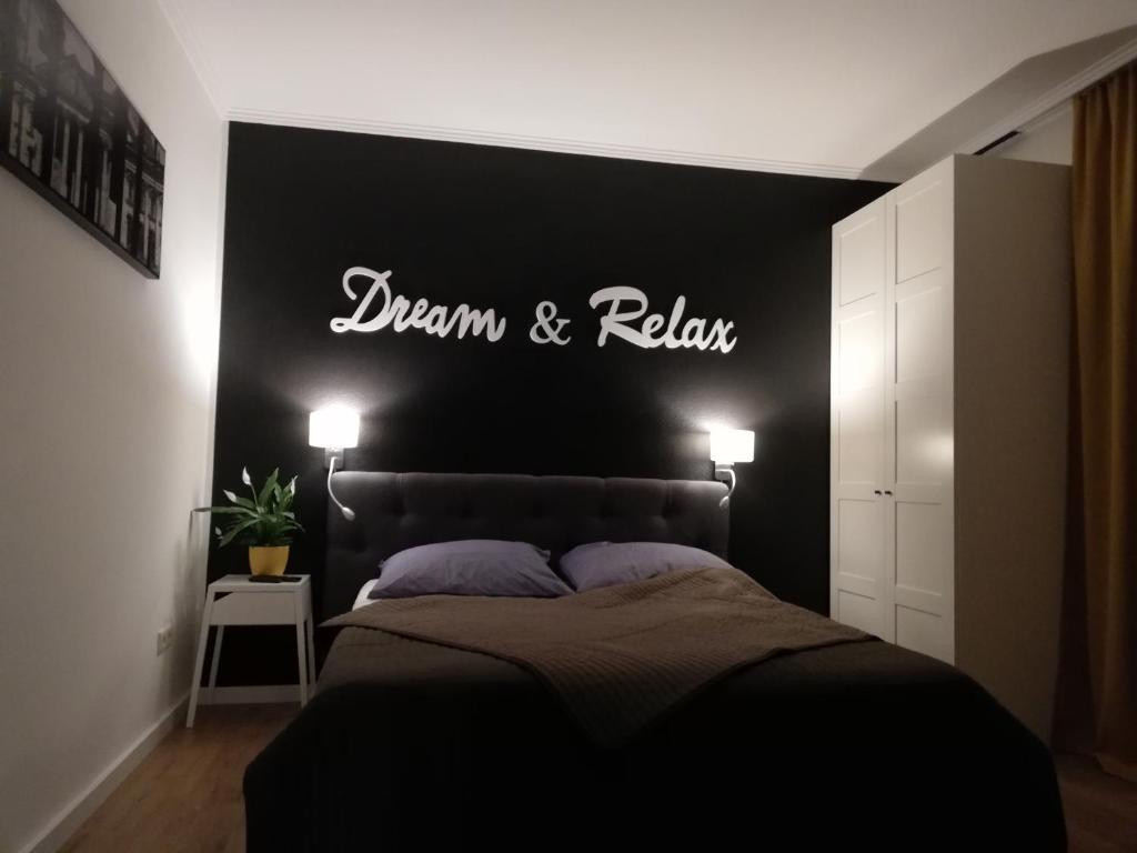 纽伦堡Dream & Relax Apartment's Messe的卧室配有一张挂有墙上标志的床