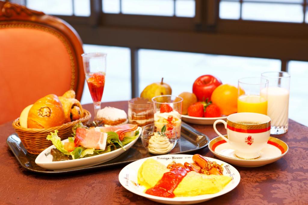 神户Hotel Konigs-Krone Kobe的餐桌,盘子上放着食物和果汁