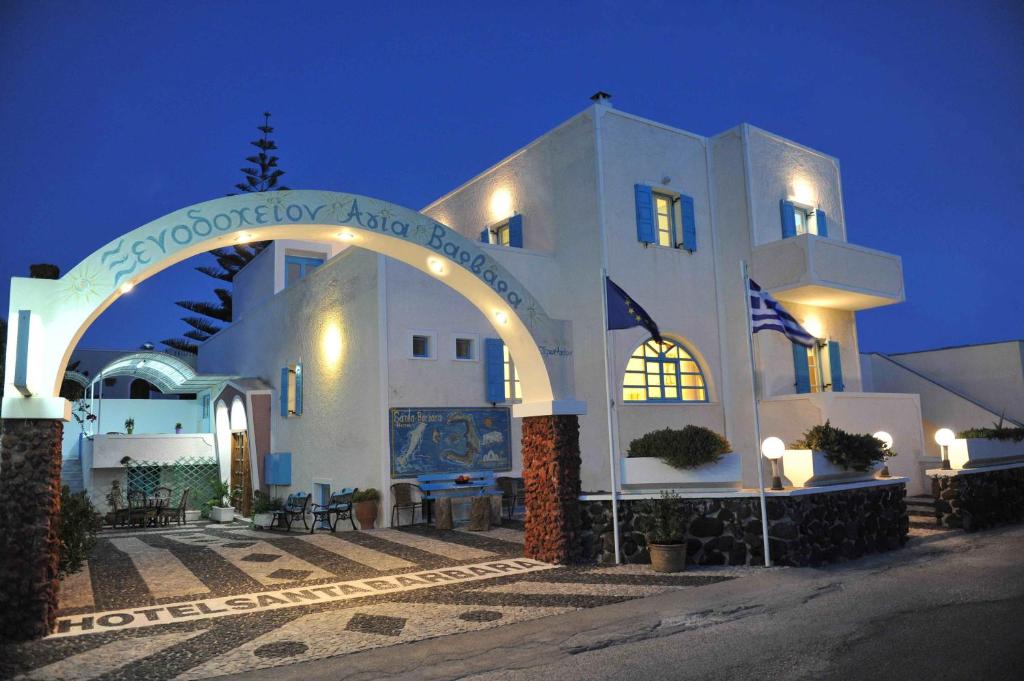 佩里萨圣巴巴拉酒店的一座白色的大建筑,晚上有拱门