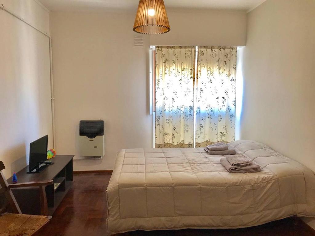 布兰卡港Lindisimo depto centro Bahía的一间卧室配有一张床、一张书桌和一个窗户。