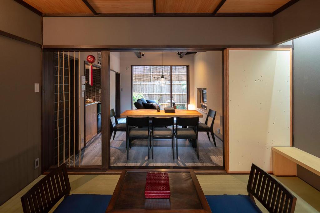 金泽Ainotsuji Machiya House的用餐室以及带桌椅的起居室。