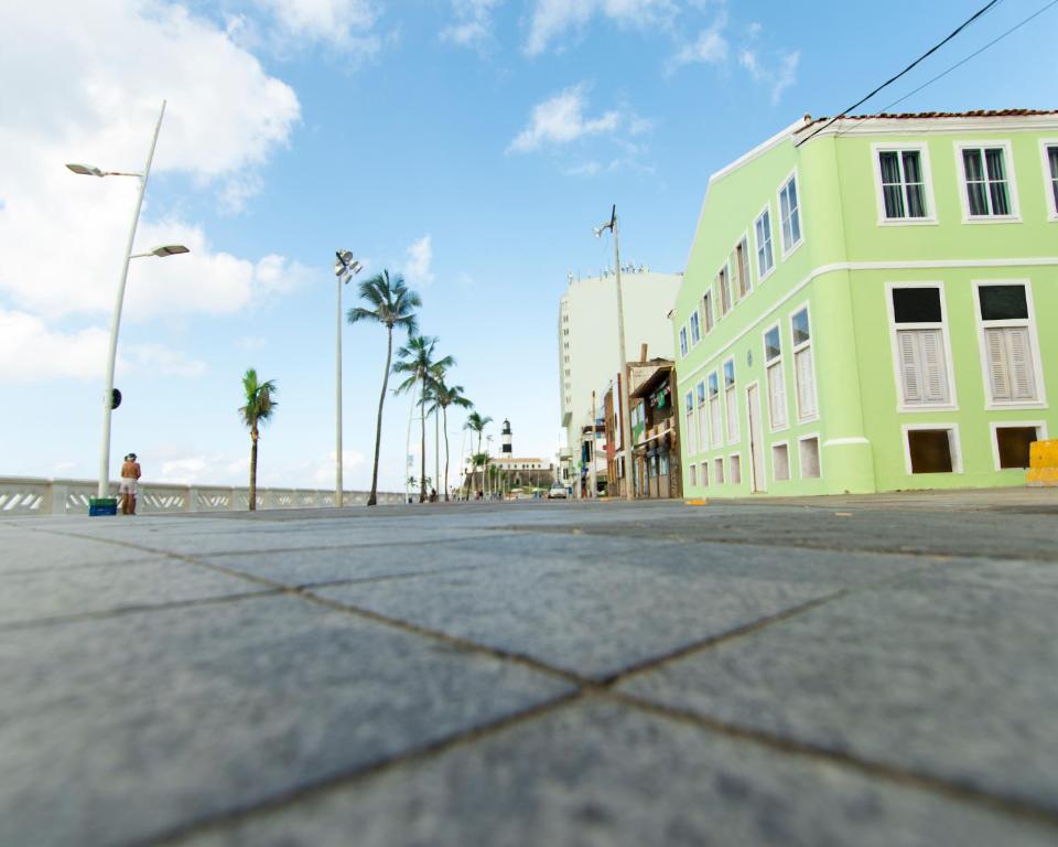 萨尔瓦多Mar à Vista Hostel的一条空的街道,有建筑和棕榈树