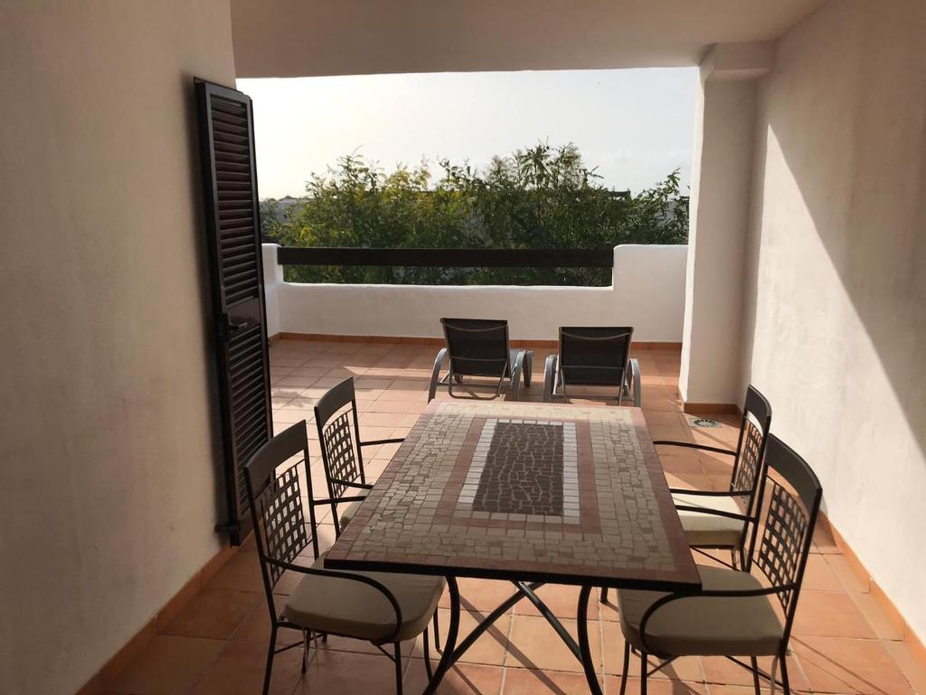 卡萨雷斯Luxury apartment set in Doña Julia Golf Course的阳台的天井配有桌椅