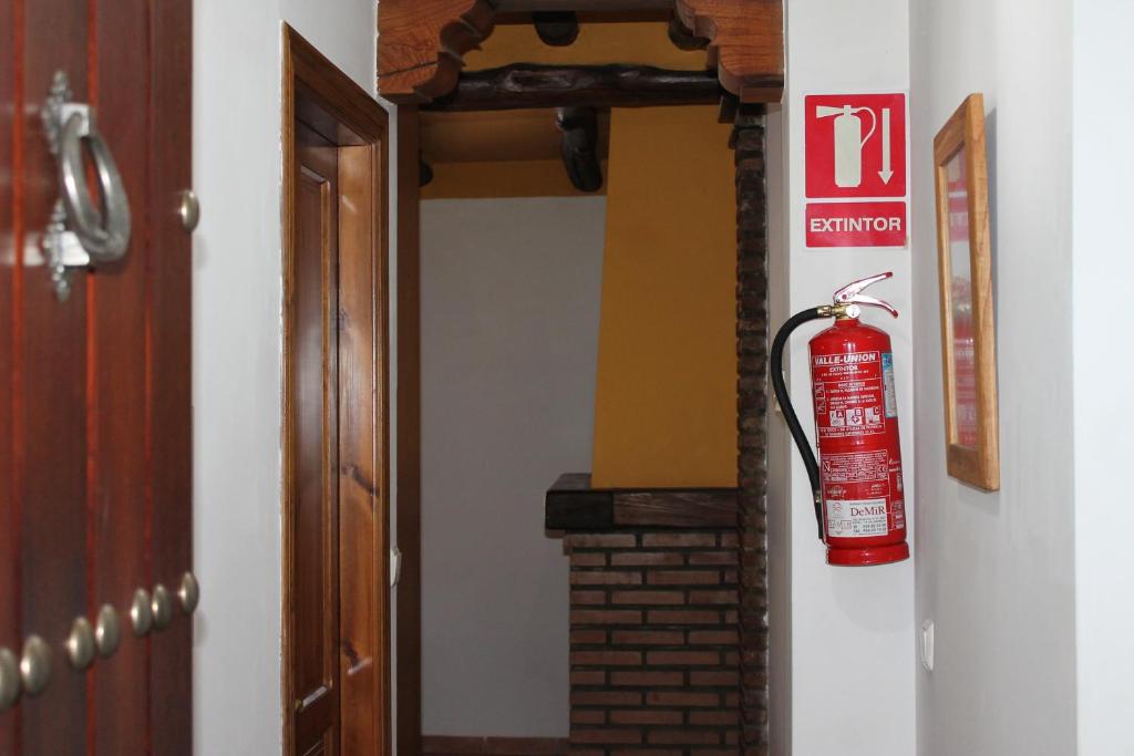 卡皮雷拉Apartamentos Rurales Rosendo: "La Pimienta"的挂在走廊墙上的灭火器