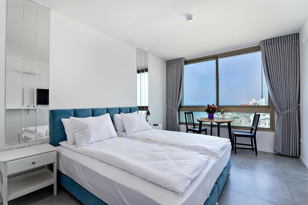 内坦亚Netanya SeaView ApartHotel的一间卧室配有一张大床和一张桌椅