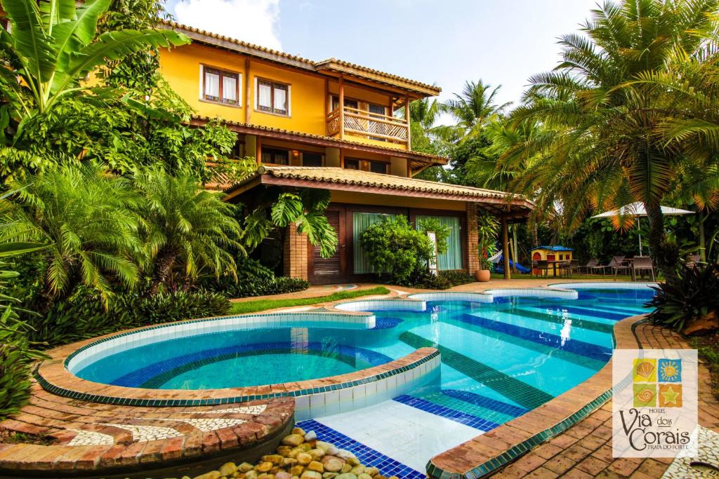 普拉亚多Hotel Via dos Corais的房屋前有游泳池的房子