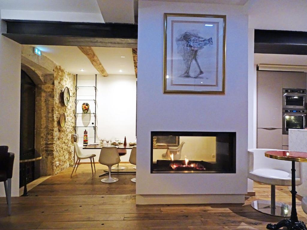 瓦尔邦讷Demeure d'hôtes Le Rocher的客厅设有壁炉和桌子