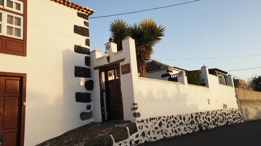 埃尔帕索Casitas La Montañita的一座白色的建筑,有门和棕榈树