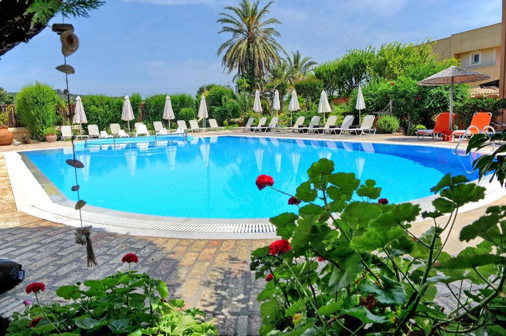 利吉亚Alkyon Apartments & Villas Hotel的一个带椅子和遮阳伞的大型游泳池
