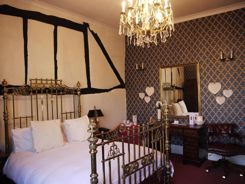 温斯洛贝尔酒店的一间卧室配有一张床、镜子和吊灯