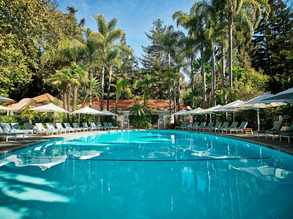 洛杉矶Hotel Bel-Air - Dorchester Collection的一个带椅子和遮阳伞的大型游泳池