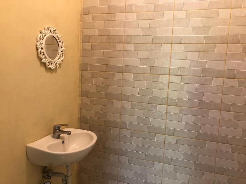 库塔Guest house KupuKupu39的浴室设有水槽和墙上的镜子