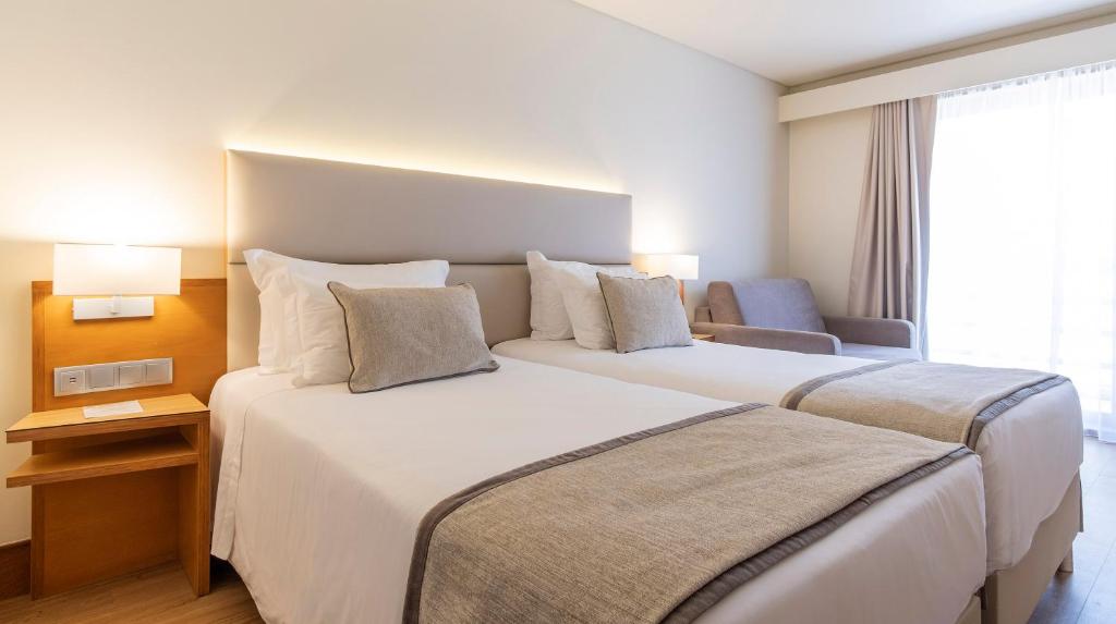 蓬塔德尔加达蓬塔德尔加达康福特茵酒店的酒店客房,设有两张床和一张沙发