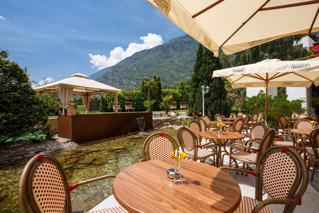 纳图尔诺全景夜曲酒店的室外餐厅设有桌椅和遮阳伞。