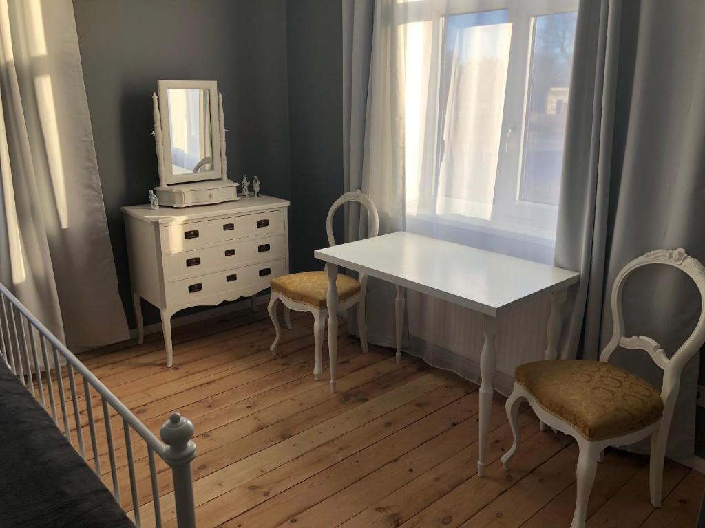 斯克伦达Skrunda Apartments Elandrum的卧室配有白色的桌子、椅子和镜子