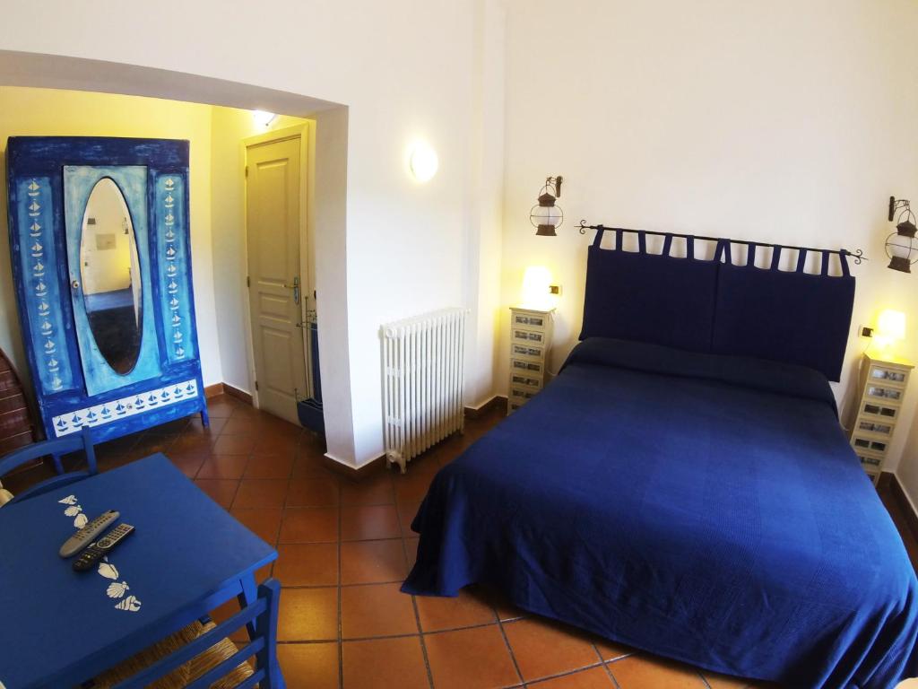 瓦莱克罗夏Agriturismo Terre di Mare Bordighera的一间卧室配有蓝色的床和镜子