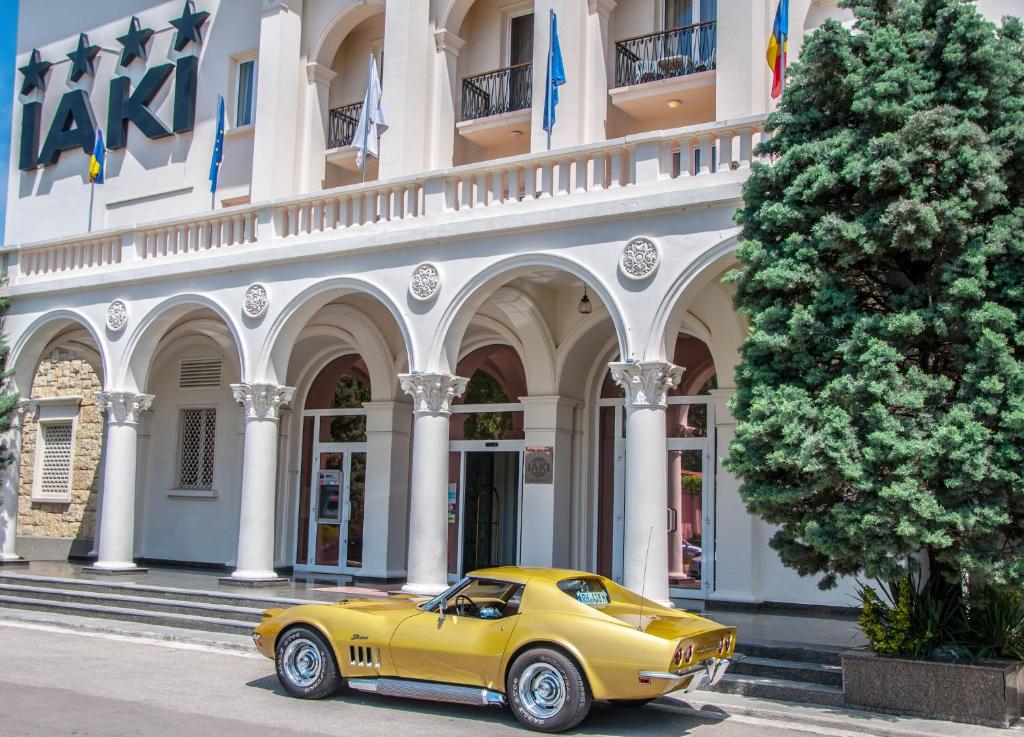 马马亚拉凯Spa酒店的停在大楼前的黄色汽车
