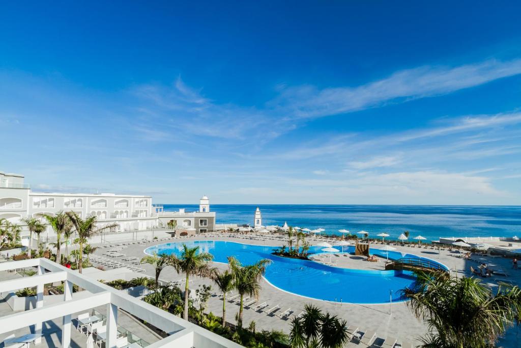 甘迪亚海滩Royal Palm Resort & Spa - Adults Only的从度假村的阳台可欣赏到游泳池和海洋的景色