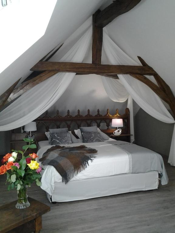 BourréLe Manoir des Roches的一间卧室配有一张带天蓬的白色床