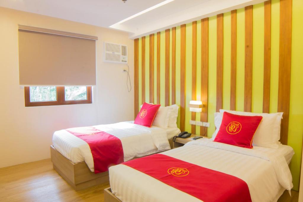 卢塞纳Hotel Rosita的黄色和红色条纹的客房内的两张床
