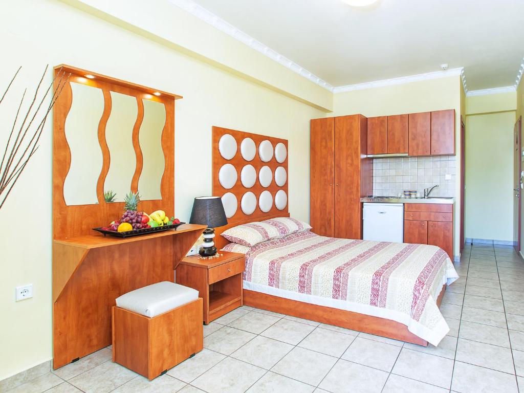奥林匹亚基·阿克蒂卡萨迪马尔公寓的一间卧室配有一张床和一张桌子及一碗水果
