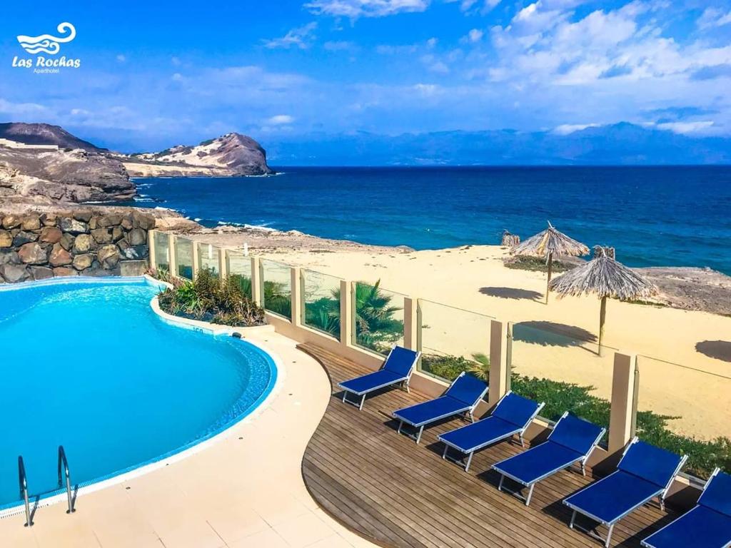 明德卢罗恰斯公寓式酒店的一个带游泳池和椅子的度假胜地和大海