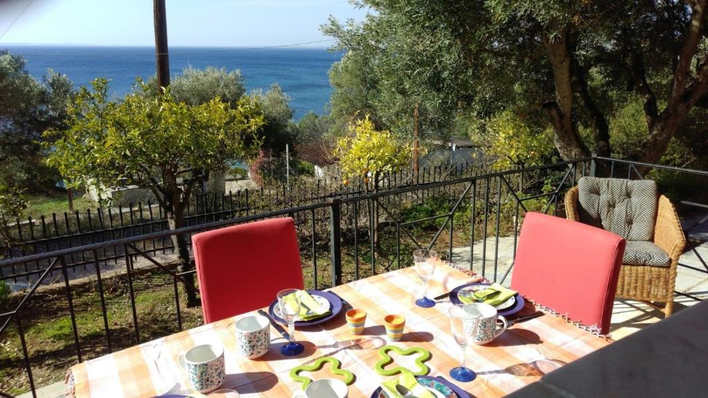 普萨克迪亚Gerakina beach cottage的一张桌子、红色的椅子和一张桌子,上面有食物