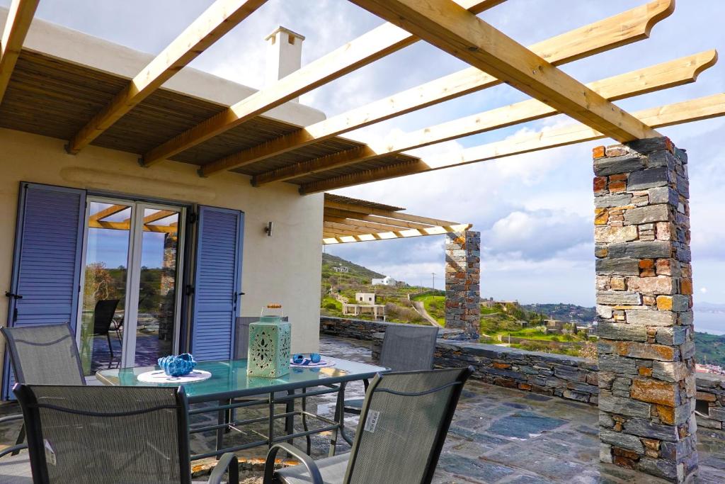 伊利达Cycladic Villa with sea view!的庭院内带桌椅的用餐室