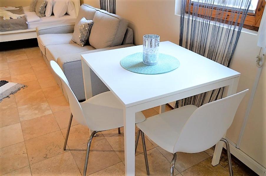 杰尔Downtown Apartments DeLuxe的客厅配有沙发和白色桌椅