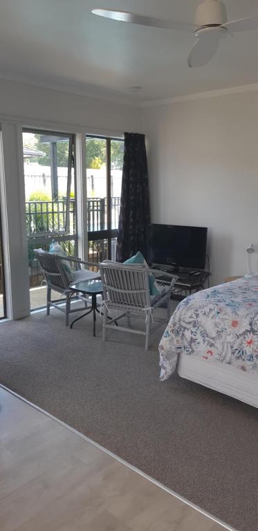 凯里凯里Kerikeri Central Apartment的一间卧室配有一张床铺和椅子,设有一个阳台