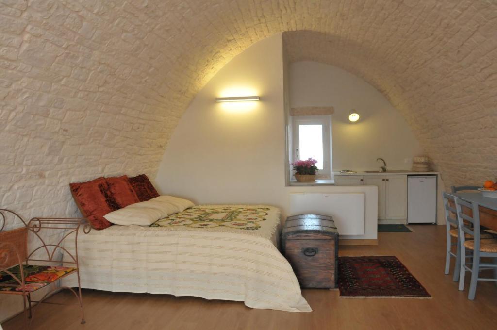 阿尔贝罗贝洛Palazzo Agrusti - Residenza D'Epoca的一间卧室配有一张床铺和一张桌子,还设有一间厨房