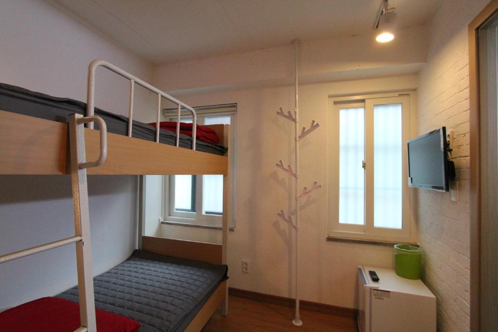 首尔贝麦宾馆的一间小房间,配有双层床和电视
