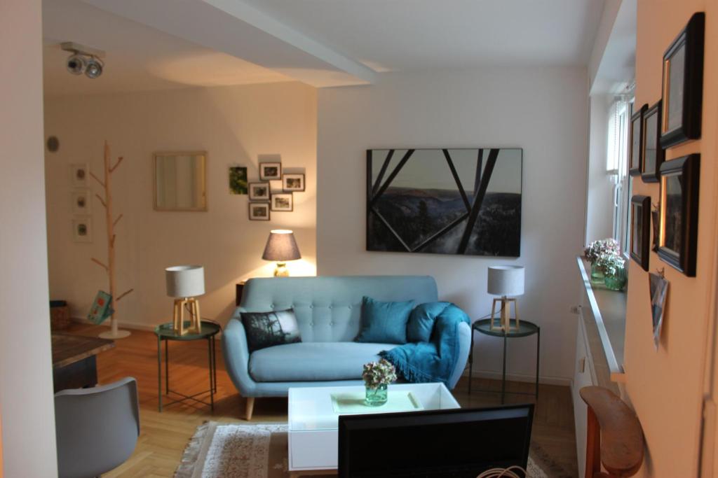 巴登-巴登Schönes Appartement mit Gartenblick的客厅配有蓝色的沙发和桌子
