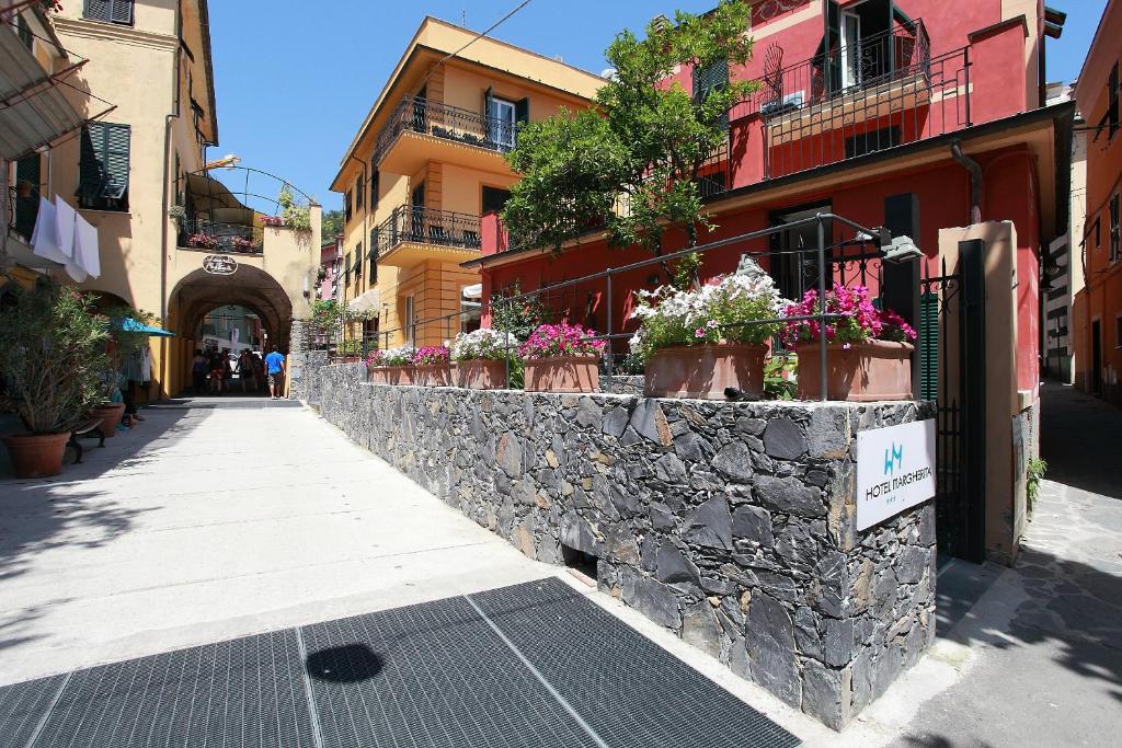 蒙特罗索阿尔马雷玛格丽特酒店的街道上一堵石墙,上面有盆栽植物