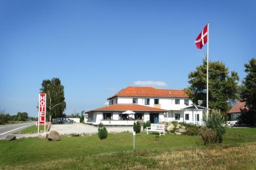 腓特烈西亚Hotel Medio Fredericia的前面有旗帜的大白色房子