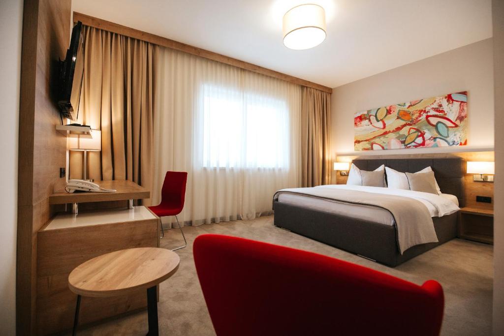 ČepinHotel Zelenkrov的酒店客房配有一张床铺和一张桌子。