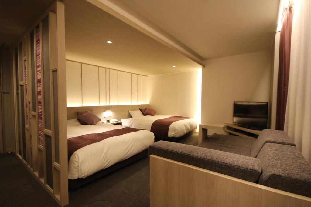 盛冈凯塔酒店的酒店客房,设有两张床和一张沙发