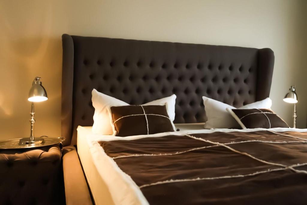 菲尔恩海姆Kant-Haus的一间卧室配有一张带黑色床头板和枕头的床。