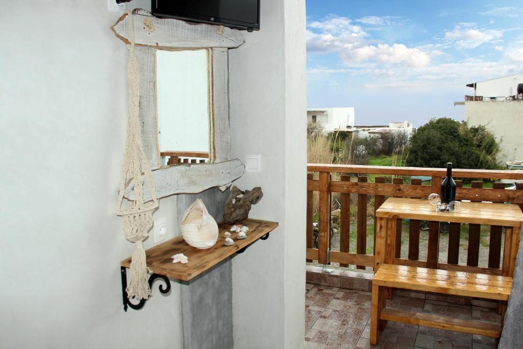 罗德镇Christos studios and family apartments的客房设有带电视和长凳的阳台。