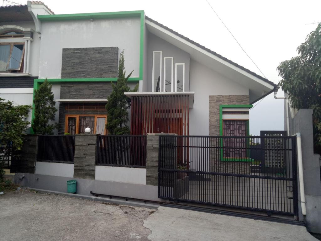 万隆Homestay Syariah Cileunyi, Bandung Timur的前面有黑门的房子