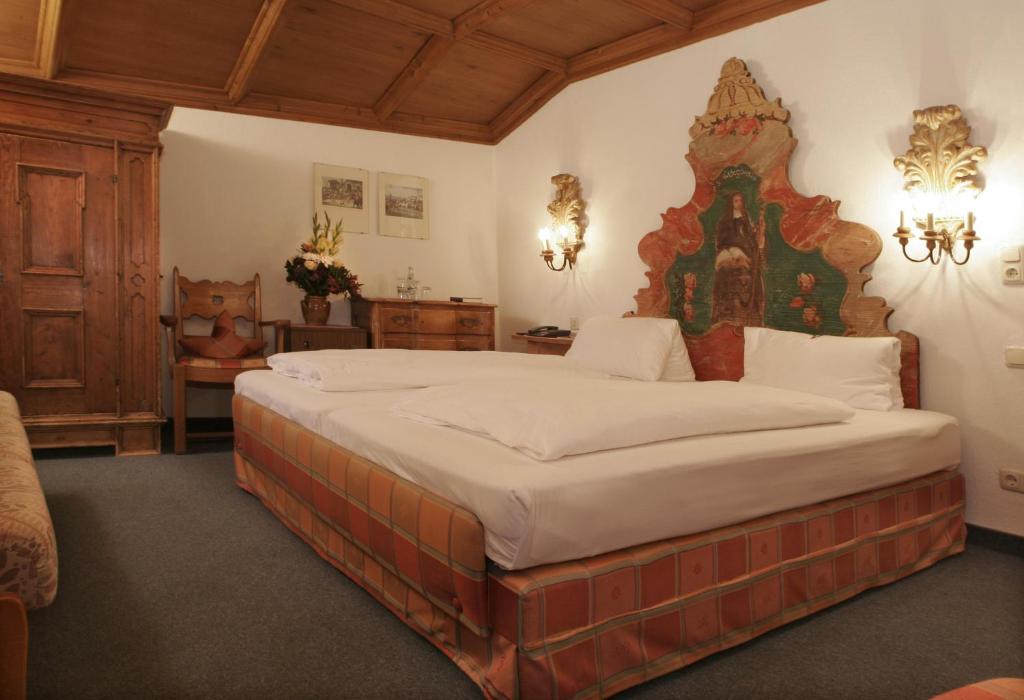 米滕瓦尔德爱普玫瑰酒店的一间卧室,卧室内配有一张大床