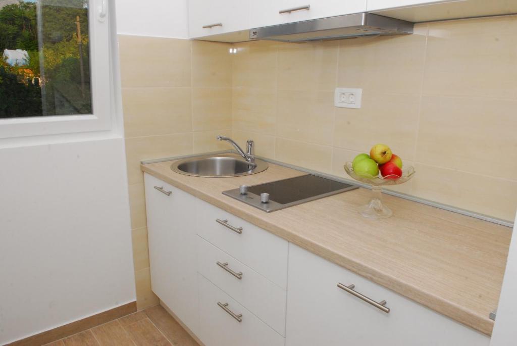 东兹斯托里弗Hera Apartment的厨房配有水槽和一碗水果