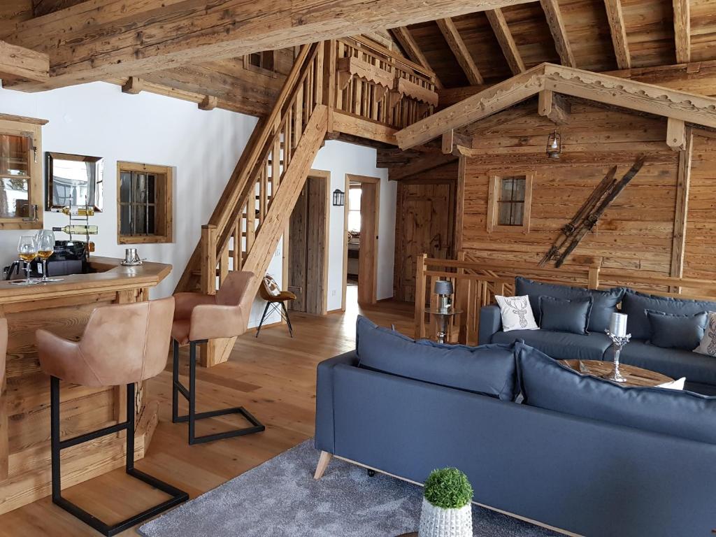 格英CHALET BELLE KAISER by Belle Stay的客厅设有蓝色的沙发和木制天花板。
