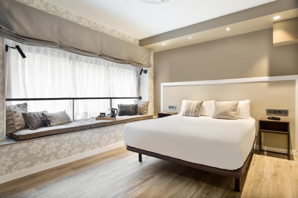 巴塞罗那阿卡德壮丽酒店的卧室设有一张白色大床和一扇窗户。