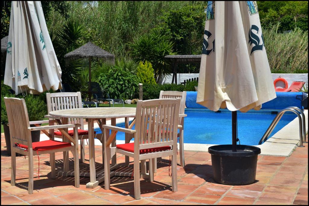 RíogordoMolino de Las Tablas的游泳池旁配有遮阳伞的桌椅