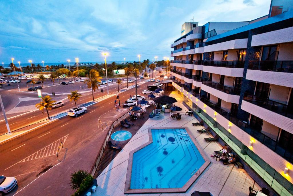 阿拉卡茹阿夸瑞斯普拉伊亚酒店的街道旁的一座带游泳池的建筑