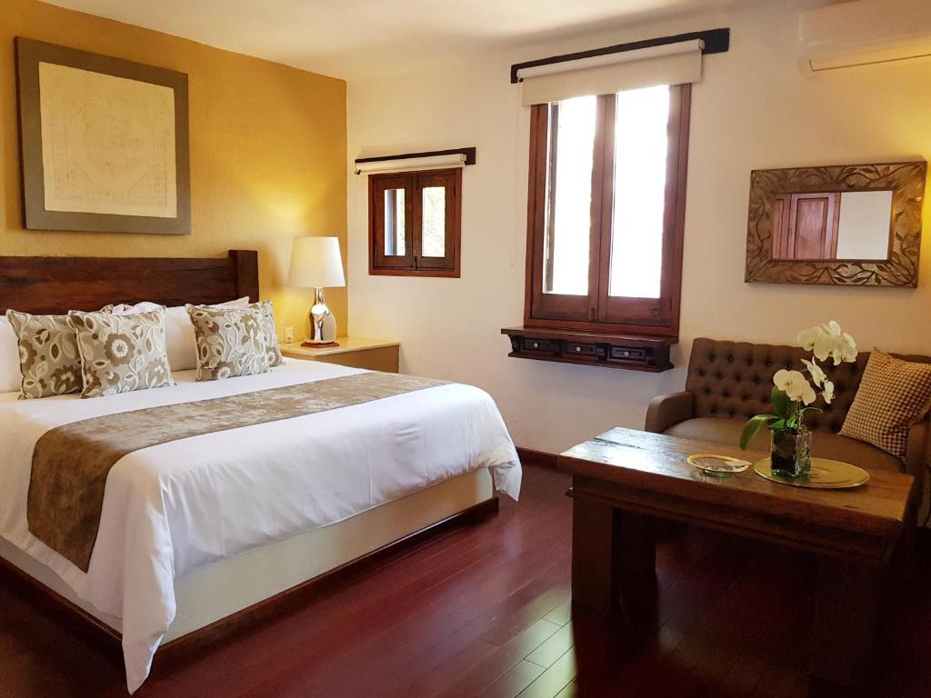 莫雷利亚Casa Embrujo Morelia - Boutique的卧室配有1张床、1张桌子和1把椅子