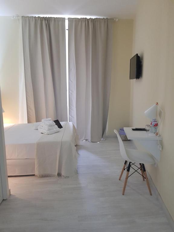 马德里Le Petit Palü-Fuencarral的一间白色卧室,配有床、书桌和电视