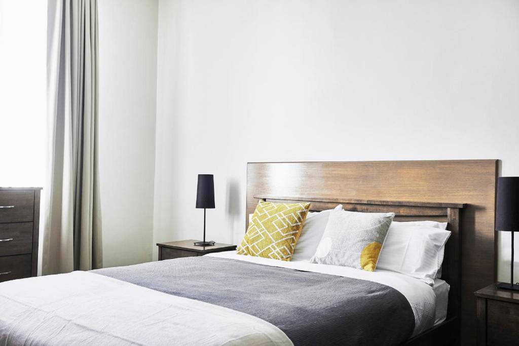 墨尔本Plough Hotel的一间卧室配有一张大床和木制床头板