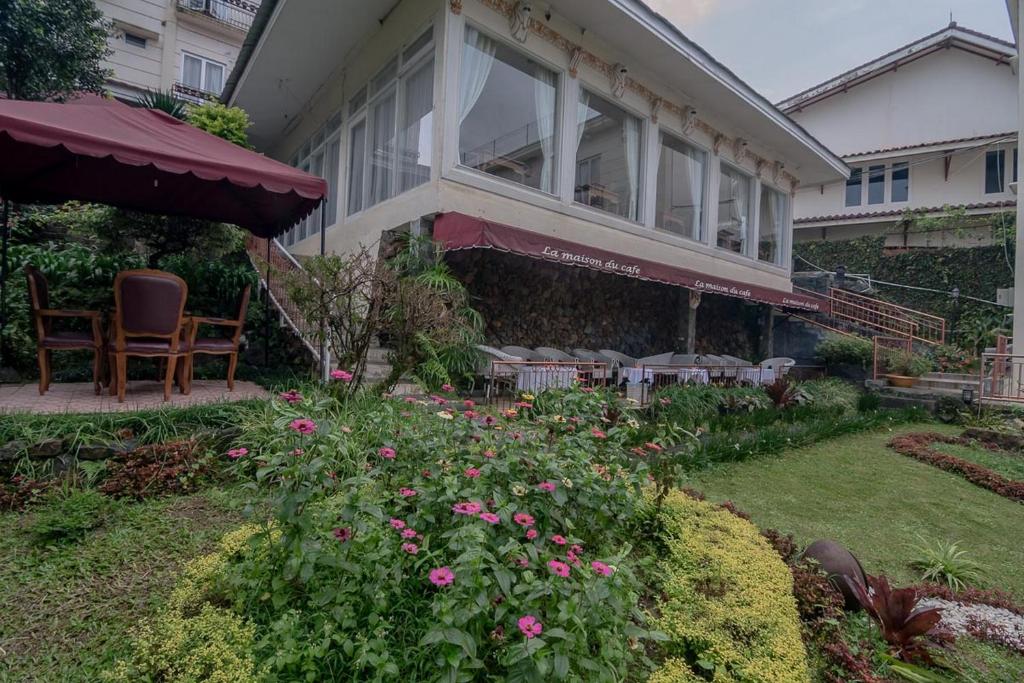 GegarbensangUrbanview Hotel Mon Bel Cibodas的房屋设有一座带椅子和鲜花的庭院